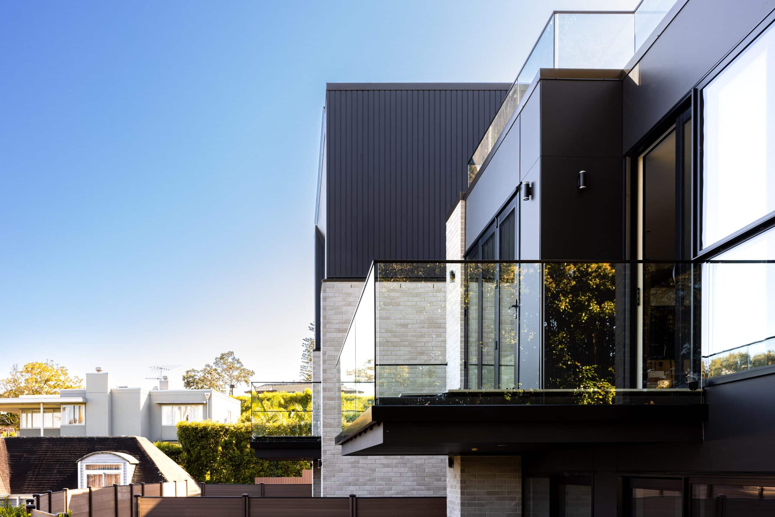 Modern residential glass balcony railing installed on a contemporary multi-level suburban home.